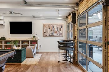 A room with a pool table and a bar area.